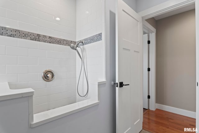 bathroom featuring hardwood / wood-style floors and tiled shower