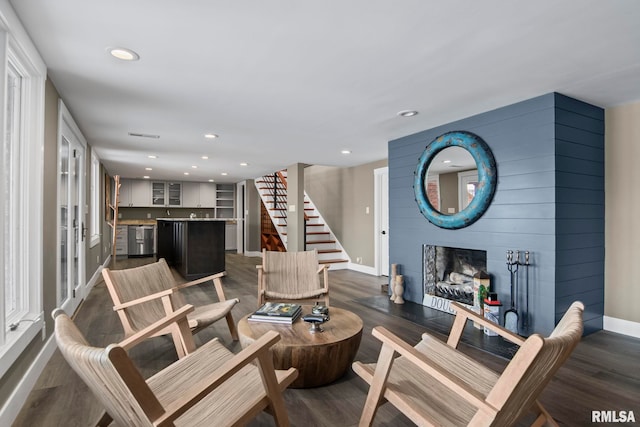 living room with dark wood-type flooring and a fireplace