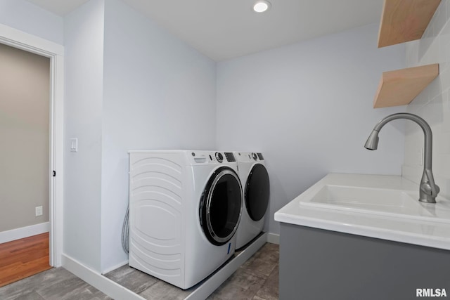 laundry area with washing machine and dryer, sink, and dark wood-type flooring