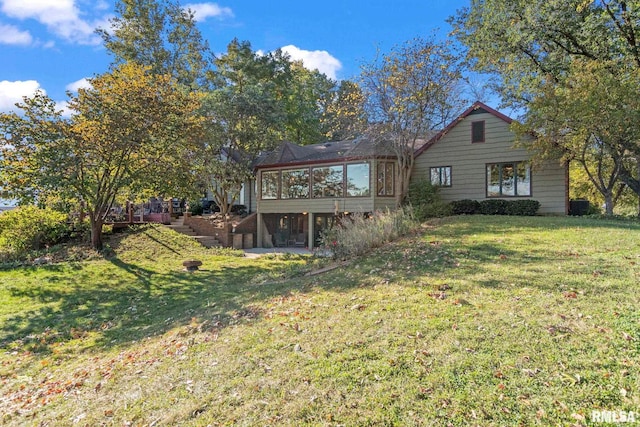 back of house with a sunroom and a yard