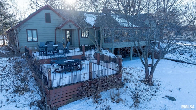 snow covered house featuring a wooden deck