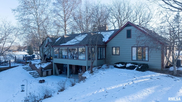 snow covered house with a sunroom