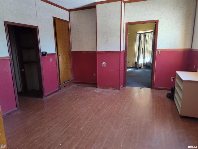 unfurnished room with dark hardwood / wood-style flooring and ornamental molding