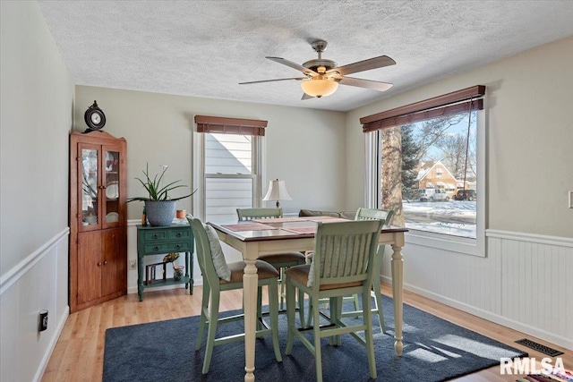 dining room featuring ceiling fan, a textured ceiling, and light hardwood / wood-style flooring