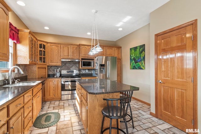 kitchen featuring decorative backsplash, appliances with stainless steel finishes, glass insert cabinets, a sink, and a kitchen island