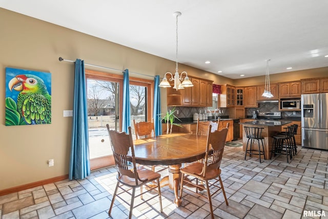 dining space featuring baseboards, stone finish flooring, recessed lighting, and an inviting chandelier