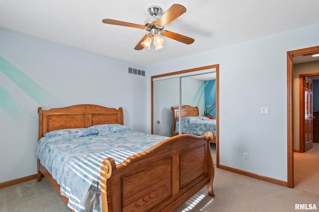 bedroom featuring a closet, visible vents, a ceiling fan, light carpet, and baseboards