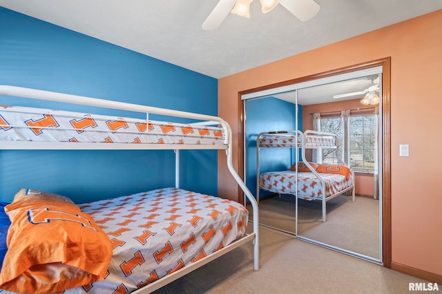 carpeted bedroom with a closet, ceiling fan, and baseboards