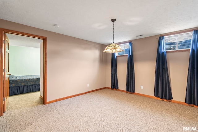 empty room with carpet floors, visible vents, baseboards, and a wealth of natural light