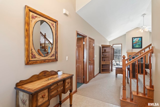 corridor with light tile patterned floors, light carpet, vaulted ceiling, baseboards, and stairs