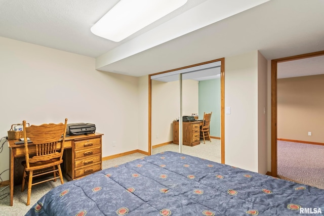 carpeted bedroom with a closet and baseboards