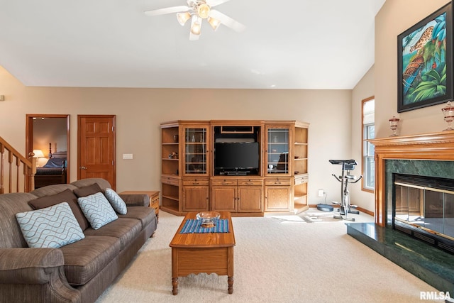 living room with a premium fireplace, stairway, vaulted ceiling, and light colored carpet