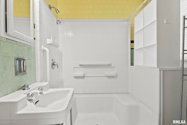 bathroom with tile walls, backsplash, and sink