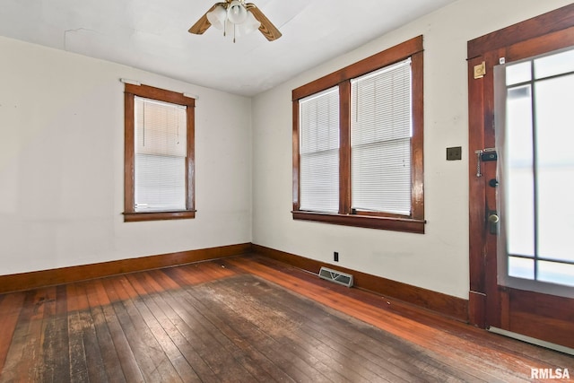 unfurnished room with ceiling fan, dark wood-type flooring, and a healthy amount of sunlight