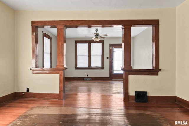 interior space featuring decorative columns, ceiling fan, and dark hardwood / wood-style floors