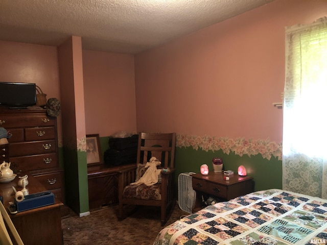 bedroom featuring a textured ceiling and dark carpet