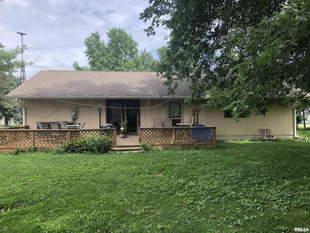 back of property with a yard and a wooden deck