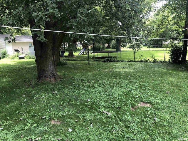 view of yard with a playground and a trampoline