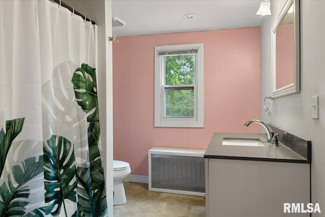 bathroom featuring toilet, vanity, and radiator