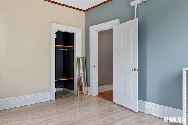 unfurnished bedroom featuring a closet, crown molding, and light hardwood / wood-style flooring