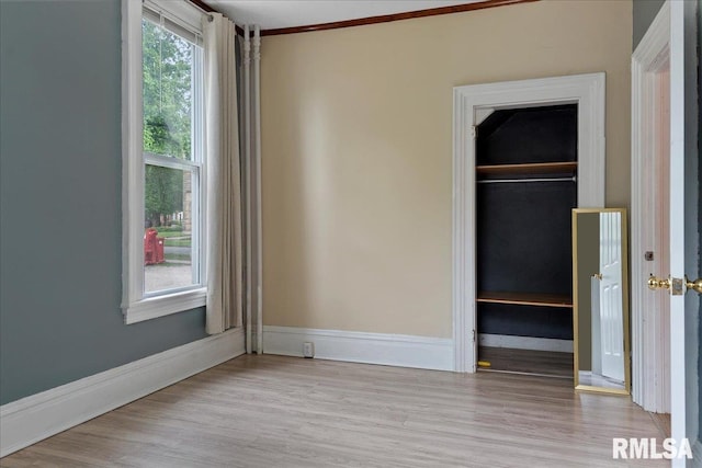 unfurnished bedroom with a closet, ornamental molding, and light hardwood / wood-style floors