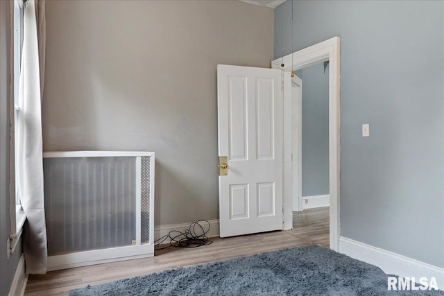 unfurnished room featuring light hardwood / wood-style floors and radiator