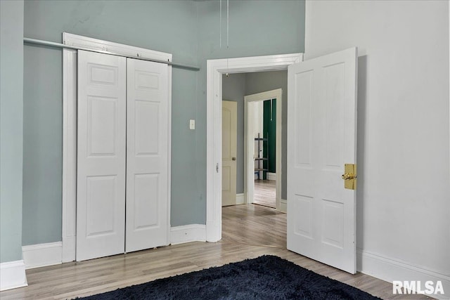 unfurnished bedroom with a closet and light hardwood / wood-style floors