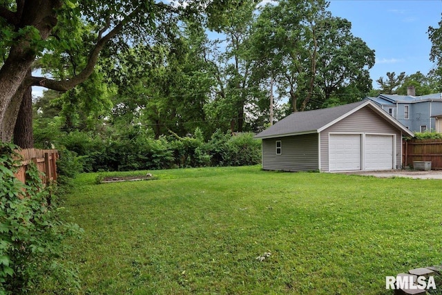 view of yard with a garage and an outbuilding