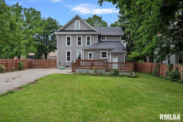 rear view of house featuring a yard and a wooden deck