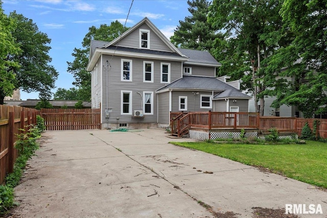 rear view of property with a deck and a yard