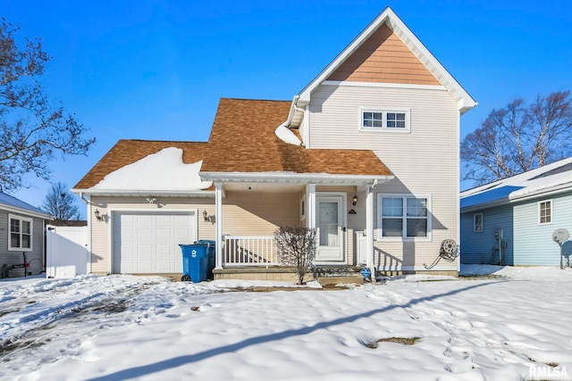 view of property with covered porch and a garage