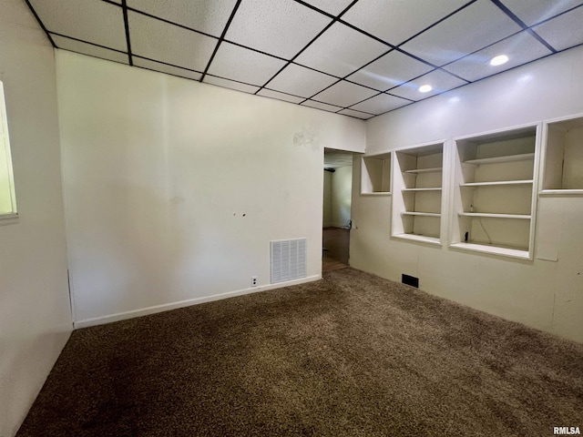 spare room with carpet flooring and built in shelves