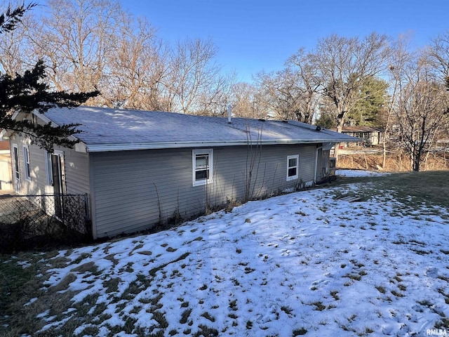 view of snow covered back of property