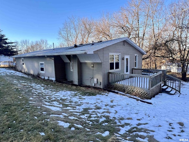 snow covered property featuring a deck