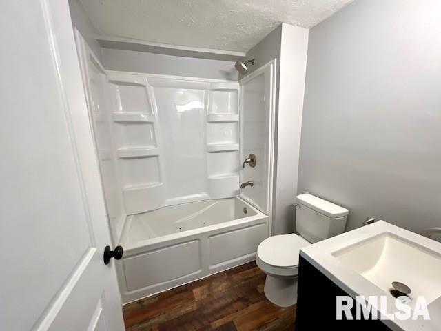 full bathroom with toilet, washtub / shower combination, wood-type flooring, a textured ceiling, and vanity