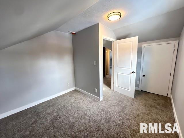 additional living space featuring carpet flooring and lofted ceiling