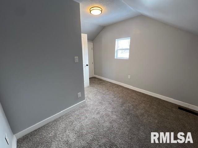 bonus room with lofted ceiling and carpet