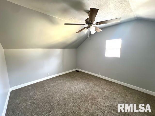 bonus room with ceiling fan, dark carpet, a textured ceiling, and lofted ceiling