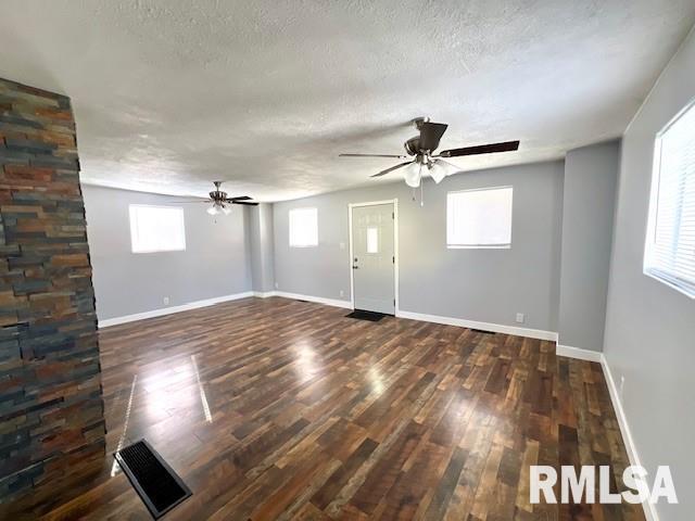 spare room featuring ceiling fan, dark hardwood / wood-style flooring, and a textured ceiling