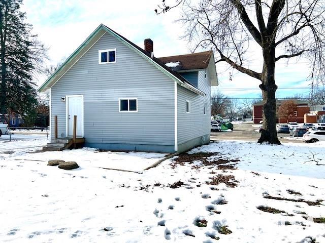 view of snow covered back of property