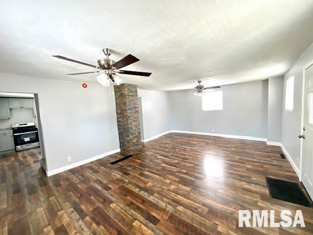 unfurnished living room featuring ceiling fan and dark hardwood / wood-style flooring