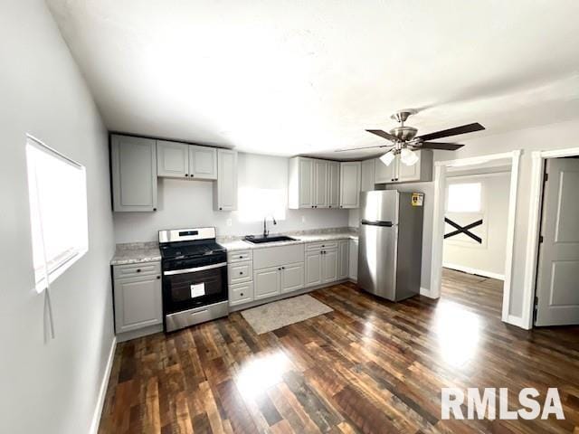 kitchen featuring ceiling fan, appliances with stainless steel finishes, gray cabinets, and dark hardwood / wood-style flooring