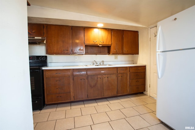 kitchen featuring lofted ceiling, black / electric stove, white refrigerator, sink, and light tile patterned floors