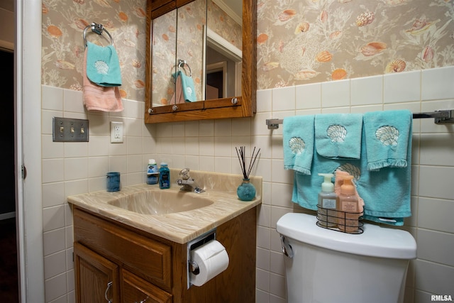 bathroom featuring tile walls, toilet, and vanity