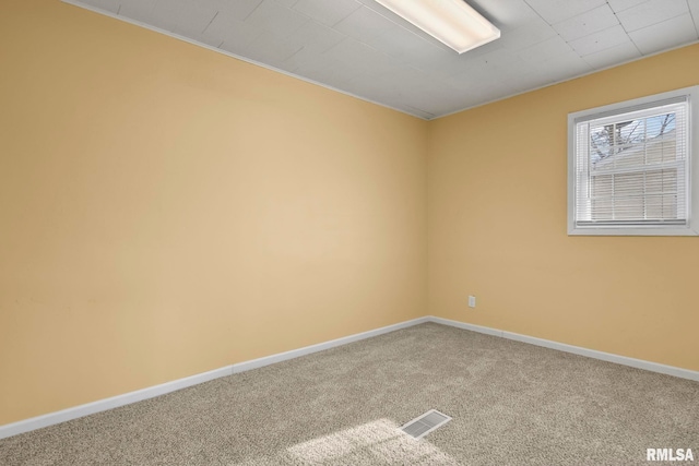 carpeted spare room with baseboards and visible vents