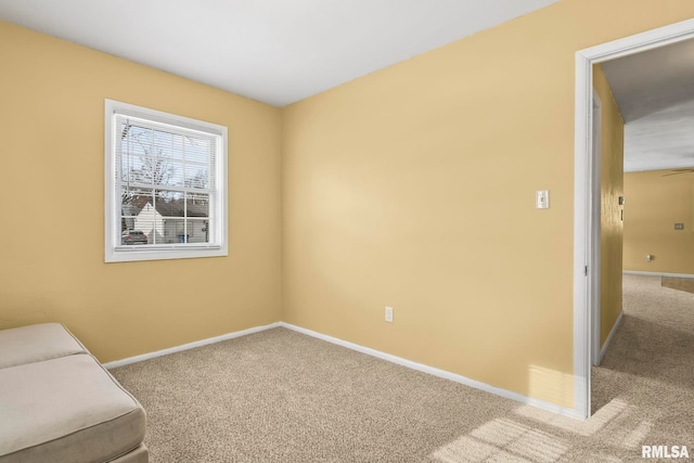 unfurnished room featuring carpet and baseboards