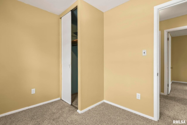 unfurnished bedroom featuring carpet floors, a closet, and baseboards