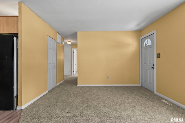 carpeted entrance foyer with visible vents and baseboards