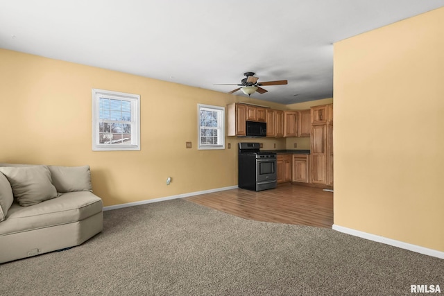 living area featuring ceiling fan, dark colored carpet, and baseboards