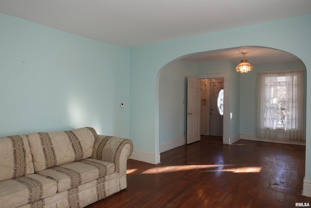 living room featuring dark wood-type flooring and a notable chandelier